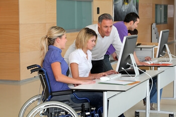 Femme en fauteuil roulant travaillant ans un bureau