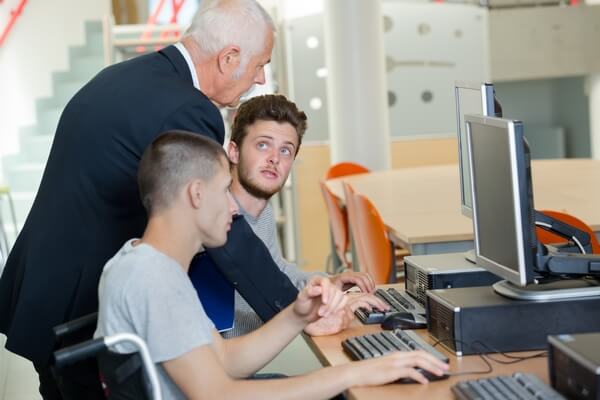 Formateur expliquant à des étudiants devant un écran